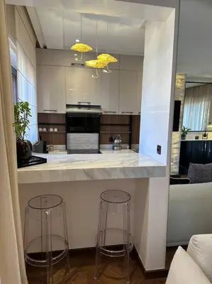 a kitchen with two bar stools and a counter at Roof top terrasse Centre-Gueliz JACUZZI in Marrakech