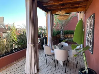 a balcony with a table and chairs and a large window at Roof top terrasse Centre-Gueliz JACUZZI in Marrakech