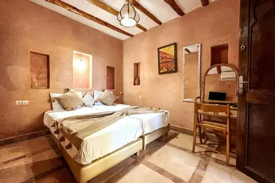 a bedroom with a large bed and a table at DAR SMAWAR top piscine chauffée 15mn centre ville in El Caïd Omar