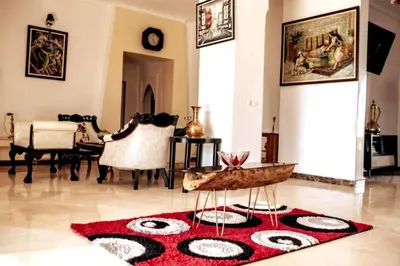 a living room with a red rug on the floor at DAR SMAWAR top piscine chauffée 15mn centre ville in El Caïd Omar