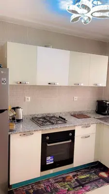 a kitchen with white cabinets and a black stove top oven at Magnifique appartement coralia in Marrakech