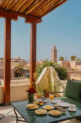 a table with plates of food on a patio at Riad Senja in Marrakech