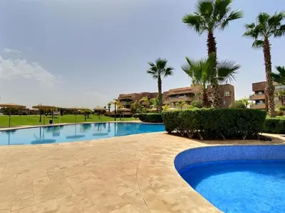 a swimming pool in a resort with palm trees at Jade Prestigia Golf in Marrakech