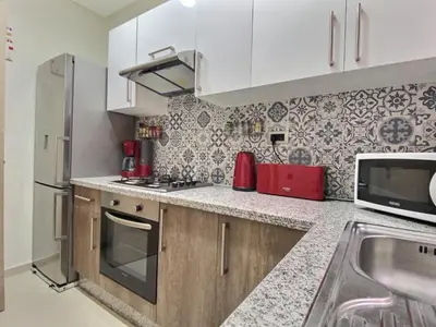 a kitchen with white cabinets and a counter top at Jade Prestigia Golf in Marrakech