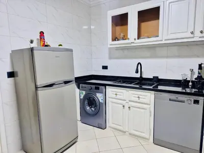 a kitchen with a refrigerator and a washing machine at Dar Bouchra, Cozy Appartement, Centre Gueliz Marrakech in Marrakech