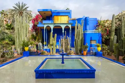 a blue building with a fountain in the middle of a garden at Dar Bouchra, Cozy Appartement, Centre Gueliz Marrakech in Marrakech
