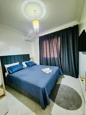 a bedroom with a blue bed and a large window at Dar Bouchra, Cozy Appartement, Centre Gueliz Marrakech in Marrakech
