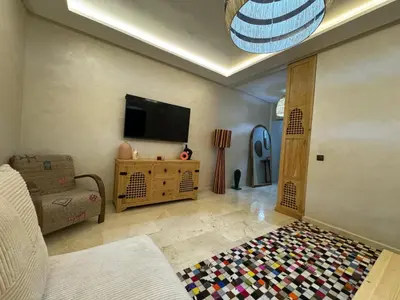 a living room with a tv and a rug at Luxury Apartment Hivernage Marrakech in Marrakech
