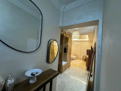 a bathroom with a sink and a mirror on a wall at Luxury Apartment Hivernage Marrakech in Marrakech
