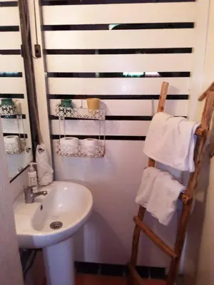 a bathroom with a white sink and a towel rack at Dar Diego des appartements au Centre de la Médina in Marrakech