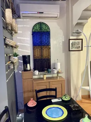 a kitchen with a table and a window in a room at Dar Diego des appartements au Centre de la Médina in Marrakech