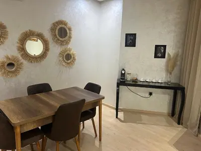 a dining room with a table and mirrors on the wall at Prestigia marrakech in Marrakech