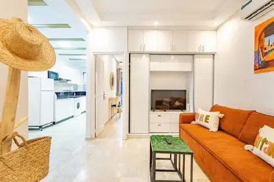 a living room with a couch and a table at Appartement avec terrasse et piscine in Marrakech