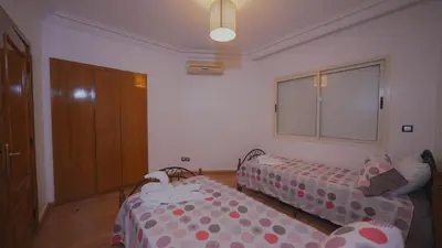 a small room with two beds and a window at Modern Apartment in Centre of Marrakech For Friends & Families in Marrakech