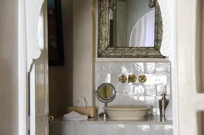 a bathroom with a sink and a mirror on a counter at Riad Emberiza Sahari in Marrakech