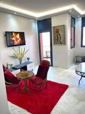 a living room with a table and chairs and a red rug at L'hivernage in Marrakech