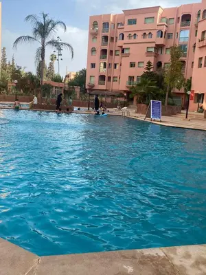 a large blue swimming pool in front of some buildings at L'hivernage in Marrakech