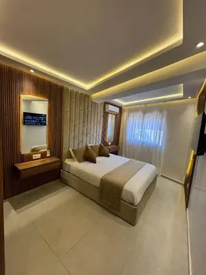 a bedroom with a large bed and a mirror at Bel Appartement Hivernage Gueliz in Marrakech
