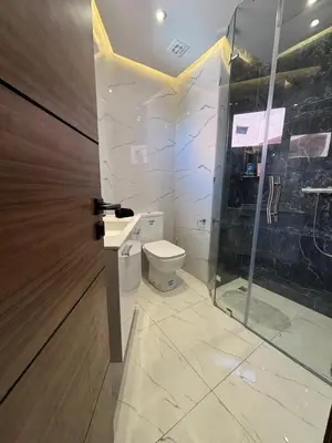 a bathroom with a toilet and a glass door at Bel Appartement Hivernage Gueliz in Marrakech