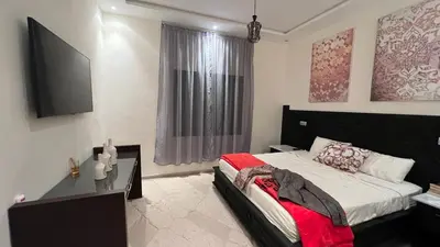 a bedroom with a bed and a television in it at Ourika immoblier in Marrakech