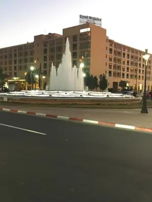 a fountain in the middle of a street with buildings at Zina in Marrakech