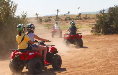a group of people riding on atvs on a dirt road at quad marrakech in Dar Caïd Layadi