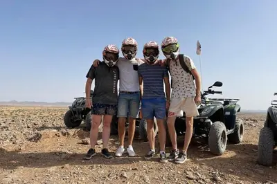 a group of four men standing next to a four wheeler at quad marrakech in Dar Caïd Layadi
