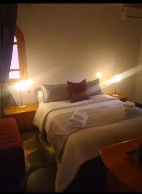 a bedroom with a large bed with two lamps at Ykar in Marrakech