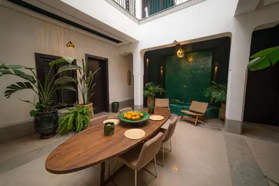 a dining room with a wooden table with a bowl of fruit on it at Riad Sabrawa in Marrakech