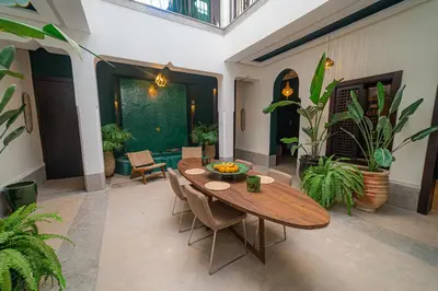 a dining room with a table and some plants at Riad Sabrawa in Marrakech