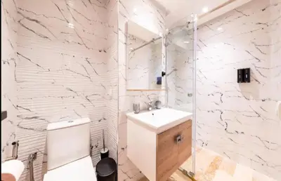 a white bathroom with a toilet and a sink at Appartement gueliz in Marrakech