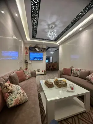 a living room with a couch and a table at Porte de Marrakech appartement familial avec jardin in Douar Bellouk