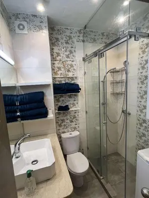 a bathroom with a shower and a toilet and a sink at Porte de Marrakech appartement familial avec jardin in Douar Bellouk