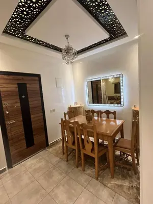 a dining room with a wooden table and chairs at Porte de Marrakech appartement familial avec jardin in Douar Bellouk