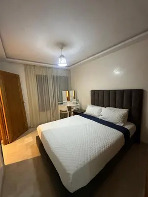 a bedroom with a large bed and a desk at Yany cosy appartement in Marrakech