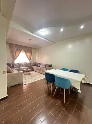 a living room with a table and chairs and a couch at Grand Appartement Piscine Guéliz in Marrakech