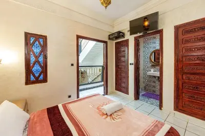 a bedroom with a bed and a large window at Riad Malika in Marrakech
