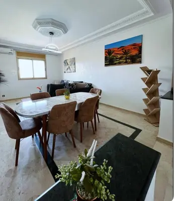 a living room with a table and a couch at New nice apartment city center swimming pool wifi in Marrakech