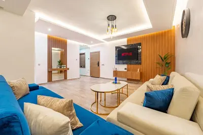 a living room with a blue couch and a tv at Luxueux appartement -70 haut gamme Guéliz in Marrakech