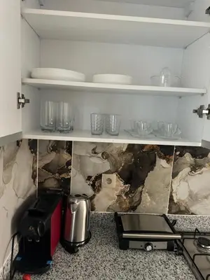 a kitchen with some plates and glasses on a shelf at Luxueux appartement -70 haut gamme Guéliz in Marrakech