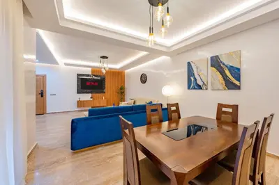 a dining room and living room with a blue couch at Luxueux appartement -70 haut gamme Guéliz in Marrakech