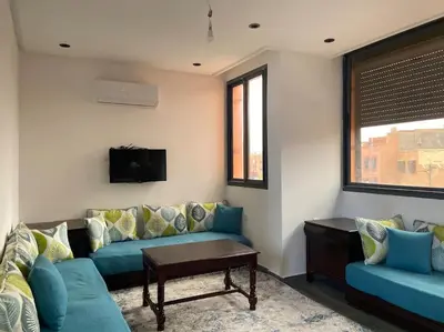 a living room with blue couches and a tv at Marrakech Dar El Hijazi 2 in Marrakech