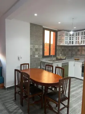 a kitchen with a wooden table and some chairs at Marrakech Dar El Hijazi 2 in Marrakech