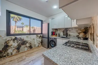 a kitchen with a sink and a stove top oven at Apprtement -74-de luxe haut gamme guéliz in Marrakech