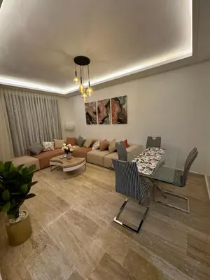 a living room with a couch and a table at Luxueuse Apparemment -143 haut standing in Marrakech