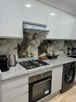 a kitchen with a stove and a washer and dryer at Luxueuse Apparemment -143 haut standing in Marrakech