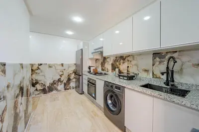 a kitchen with a washer and dryer in it at Luxueuse Apparemment -143 haut standing in Marrakech