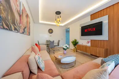 a living room with a couch and a tv at Luxueuse Apparemment -143 haut standing in Marrakech