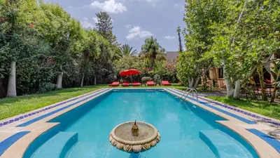 a swimming pool in a yard with trees at la villa du golf in Sfiani