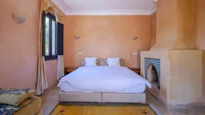 a bedroom with a bed and a fireplace at la villa du golf in Sfiani